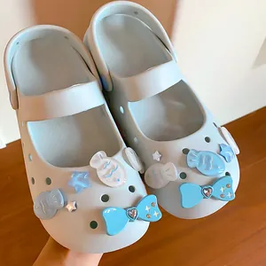Close-up view of light blue Mary Jane clogs decorated with cute DIY fish and bow charms.