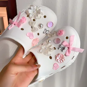 Close-up of elegant pink flower and pearl charms on white clogs DIY accessories