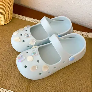 Close-up of elegant pearl and shell charms on light blue Mary Jane clogs