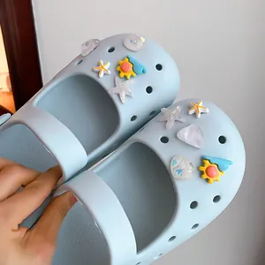 Macro view of various cute summer seashell and starfish charms for light blue DIY clogs