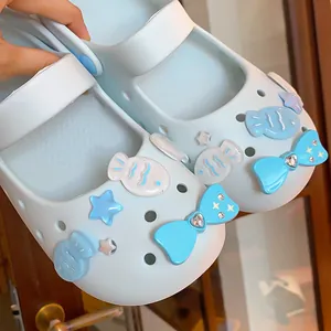 Close-up detail of light blue Mary Jane clog shoe charms featuring rhinestone bows and cute fish