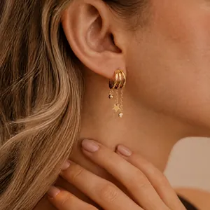 Close-up of 18K gold plated triple-layer hoop earrings with star and zircon charms