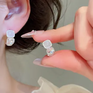 Elegantes pendientes de plata con piedra de opale lechosa y detalle de cristal facetado.