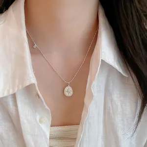 Primer plano detallado de un collar con colgante de estrella y perla plateada