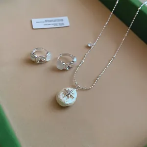 Elegante collar con colgante de estrella plateada y pendientes a juego en bandeja terciopelo