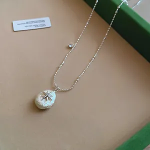 Vista detallada del collar francés de cadena de bolas de plata con colgante de perla y estrella