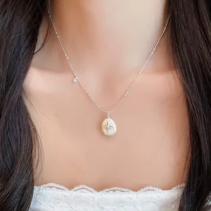 Vista detallada de un collar de perlas francés con colgante de estrella en una modelo