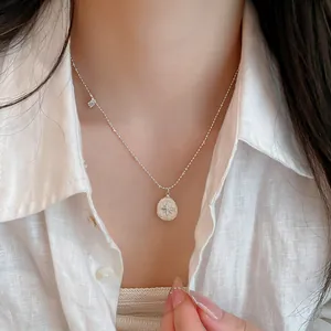 Vista detallada del collar con colgante de estrella plateada y cadena de cuentas finas