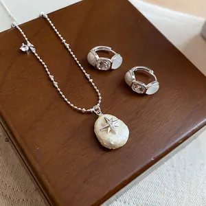 Vista detallada del conjunto elegante de collar y pendientes de estrella de perlas