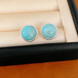 Macro detail view of elegant light blue round stud earrings inside a jewelry box