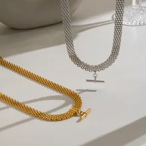 Primo piano di collane in acciaio inossidabile intrecciato oro e argento con ciondoli a T