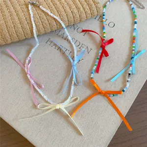 Close-up of colorful beaded necklaces with vibrant ribbon bows in summer style.