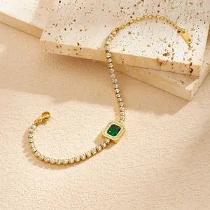 Detailweergave van een vergulde roestvrijstalen armband met een vierkante groene zirkoon