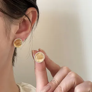 Close-up of retro round agate stud earrings with textured silver pins for women.