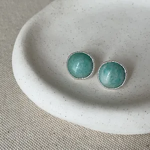 Detailed close-up view of vintage silver stud earrings with round green natural agate stone
