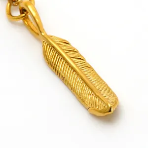 Detailed macro shot of vintage golden stainless steel feather pendant for DIY jewelry