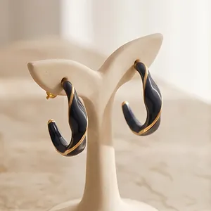 Eleganti orecchini a cerchio a C intrecciati in smalto nero placcati in oro 18 carati.