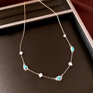 Elegant gold-plated chain necklace featuring freshwater pearls and turquoise accents