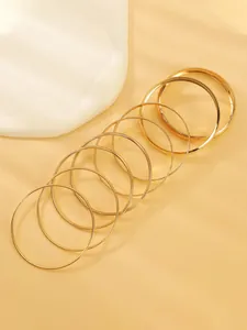 Vue détaillée d'un ensemble de bracelets joncs dorés multicouches en alliage texturé