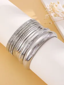 Vue détaillée d'un ensemble de joncs argentés multicouches avec strass et motifs