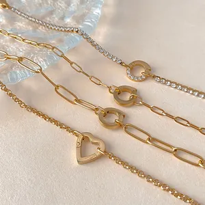 Macro view of gold stainless steel bracelets with heart and decorative circle clasps
