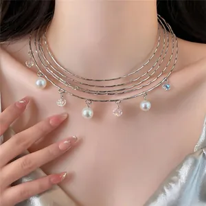 Detail of a stylish multi-layer silver choker necklace with pearls and crystal charms