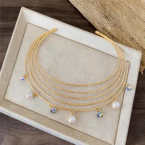 Elegant multi-layered gold choker necklace featuring white pearls and crystal charms.