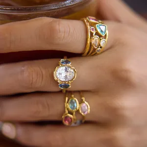 Detailed shot of gold plated stainless steel rings with colorful zircon stones on hand