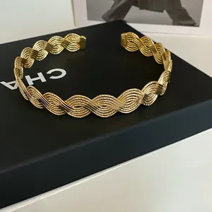 Detailansicht eines vergoldeten, geflochtenen Metallhalsbands auf einer schwarzen Box.