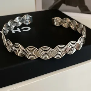 Detaillierte Nahaufnahme einer eleganten silbernen Metallkette mit gewebter Wellenstruktur