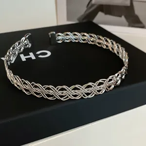 Detaillierte Nahaufnahme des aufwendigen metallischen Flechtmusters dieses silbernen Chokers