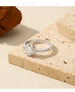 Detail of 1 carat moissanite sterling silver ring on textured stone pedestal