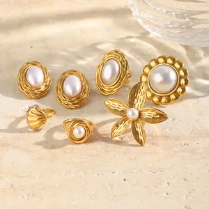 Macro shot of 18K gold plated stainless steel pearl rings and earrings set on stone