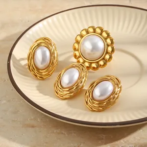 Close-up detail of luxury 18K gold plated stainless steel pearl earrings and ring set.
