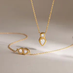 Dettaglio macro di una collana in acciaio al titanio dorato con eleganti zirconi lucidi.
