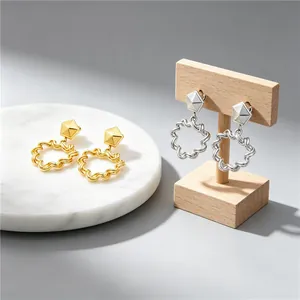 Close-up view of geometric pleated hollow heart earrings in gold and silver stainless steel
