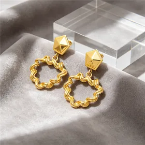 Close-up of vintage gold stainless steel earrings with wrinkled hollow hoop design.