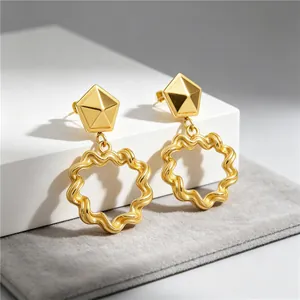 Detail shot of gold stainless steel earrings with geometric studs and wavy rings.