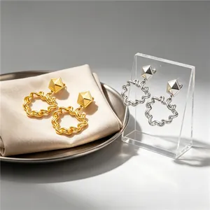 Detailed view of vintage pleated hollow heart-shaped earrings in gold and silver finishes