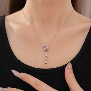Dettaglio di una collana in argento minimalista con ciondolo in zircone rosa a forma di goccia