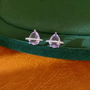 Primo piano di orecchini a lobo con zircone rosa a goccia e design scintillante