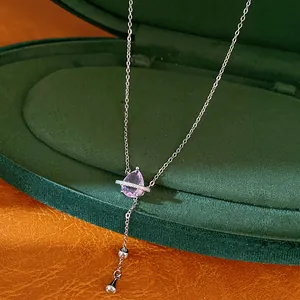 Primo piano di un ciondolo in zircone a goccia viola su una catena lariat argentata