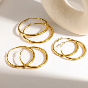 Macro view of three pairs of large 18K gold plated stainless steel hoop earrings in gold