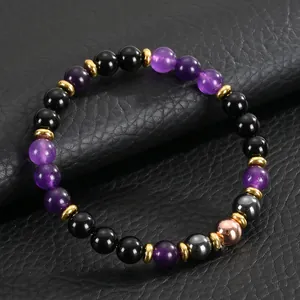 Close-up of 8mm amethyst and black onyx healing crystal bracelet on textured leather