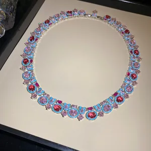 Primer plano de un collar de lujo vintage con piedras rosas, rojas y detalles turquesa