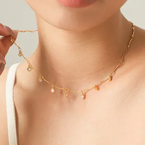 Nahaufnahme des goldenen 18K Titanstahl-Chokers mit runden Kristallanhängern.