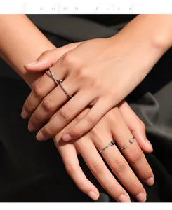 Detalle de anillos apilables de plata S925 y moissanita en la mano, diseño elegante.