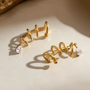 Detail view of gold stainless steel layered ear cuffs with teardrop crystal pendants