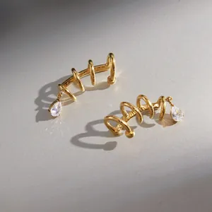 Close-up of gold-plated stainless steel spiral ear cuff with teardrop zircon detail.