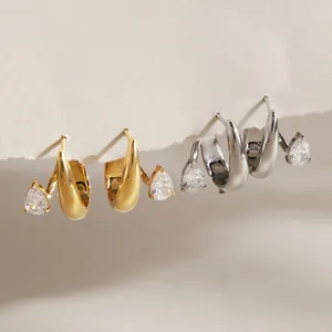 Détail de zircons en poire sur des boucles d'oreilles créoles en acier titane doré et argenté